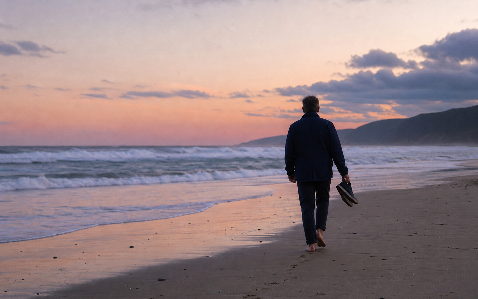 A person walking quietly by the sea at dusk